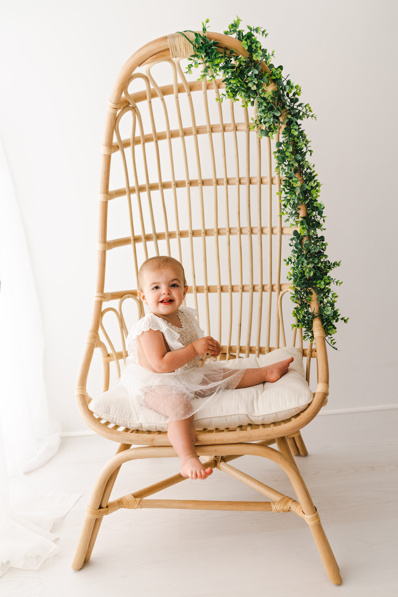baby sitting on wooden chair smiling