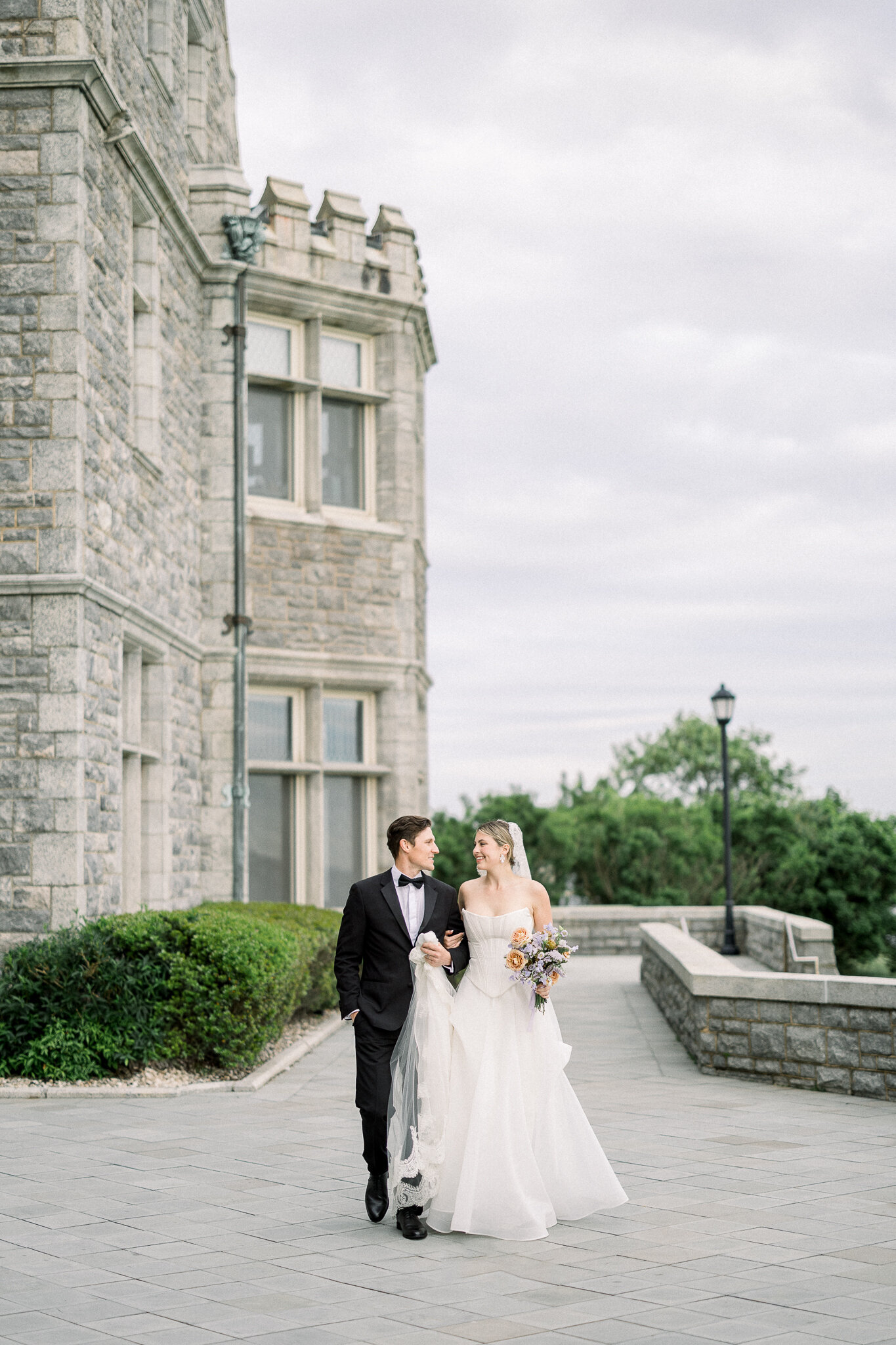 bride and groom pose in front of branford house coastal mansion