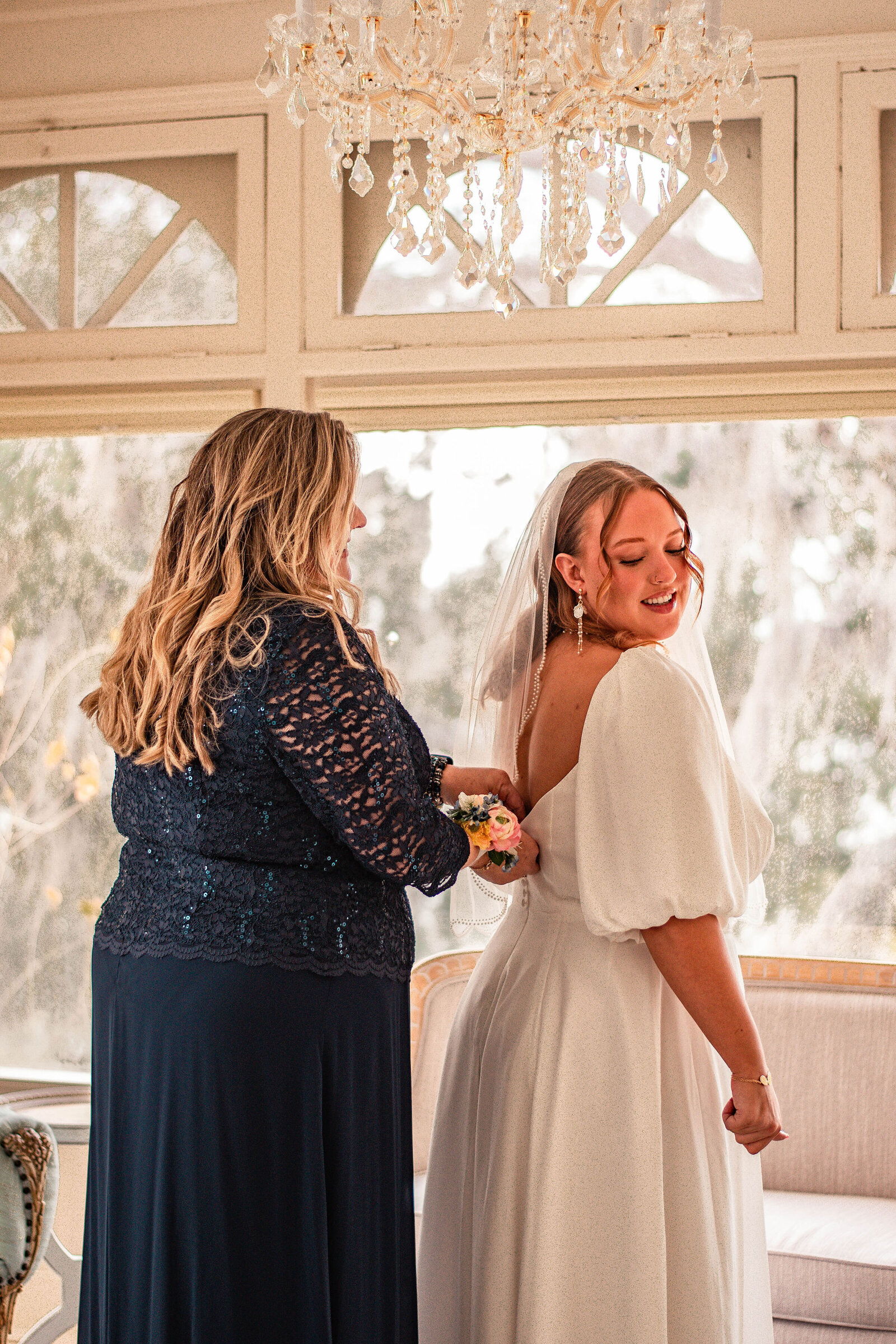 mother helping the bride in the bridal suite