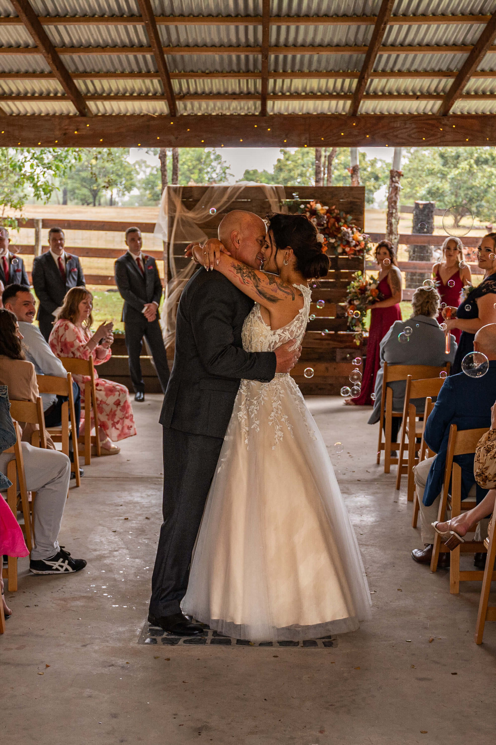A beautiful wedding ceremony held in a rustic barn, surrounded by nature, with guests enjoying the festive ambiance.