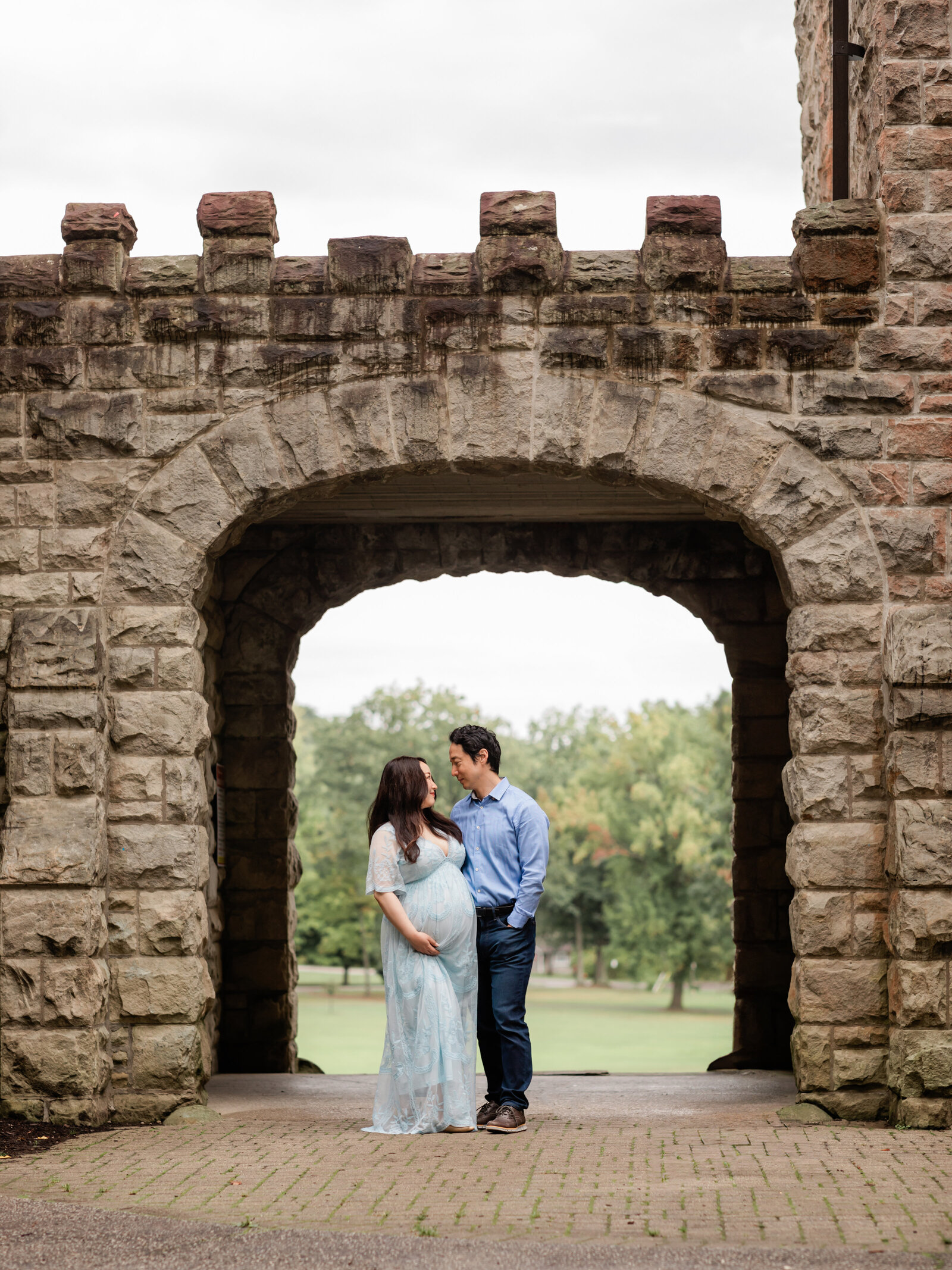 husband and wife holding pregnant belly for maternity photos at squires castle 