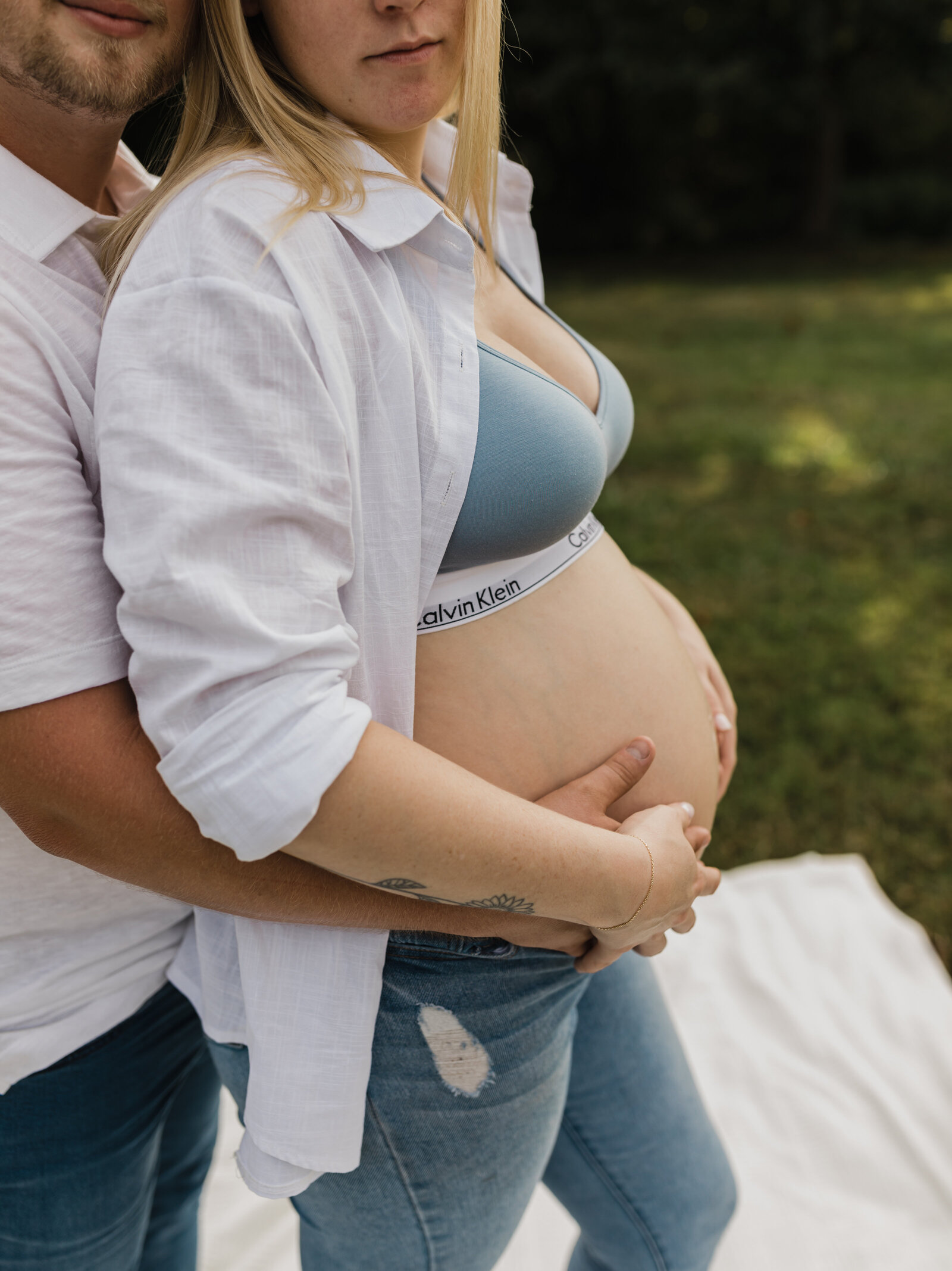 mother and father holding pregnant belly for maternity photoshoot