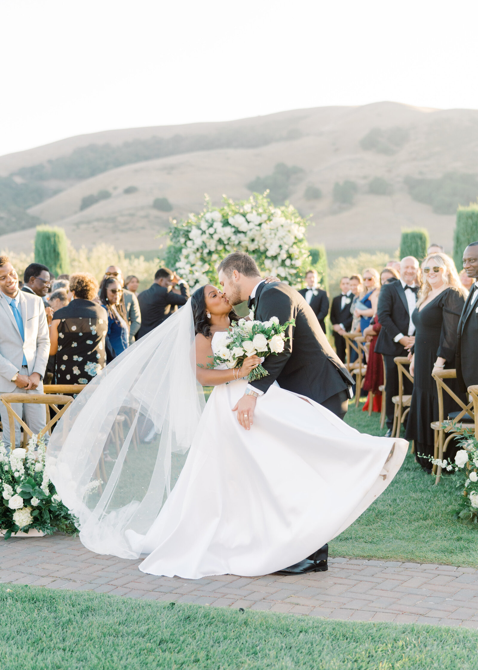 groom dipping the bride and kissing her at the ceremony