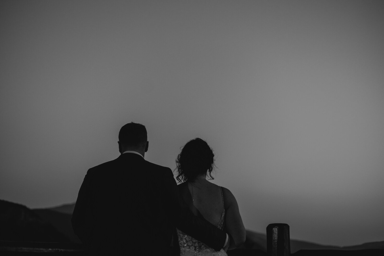 Candid black and white wedding portrait of couple at their mountaintop wedding
