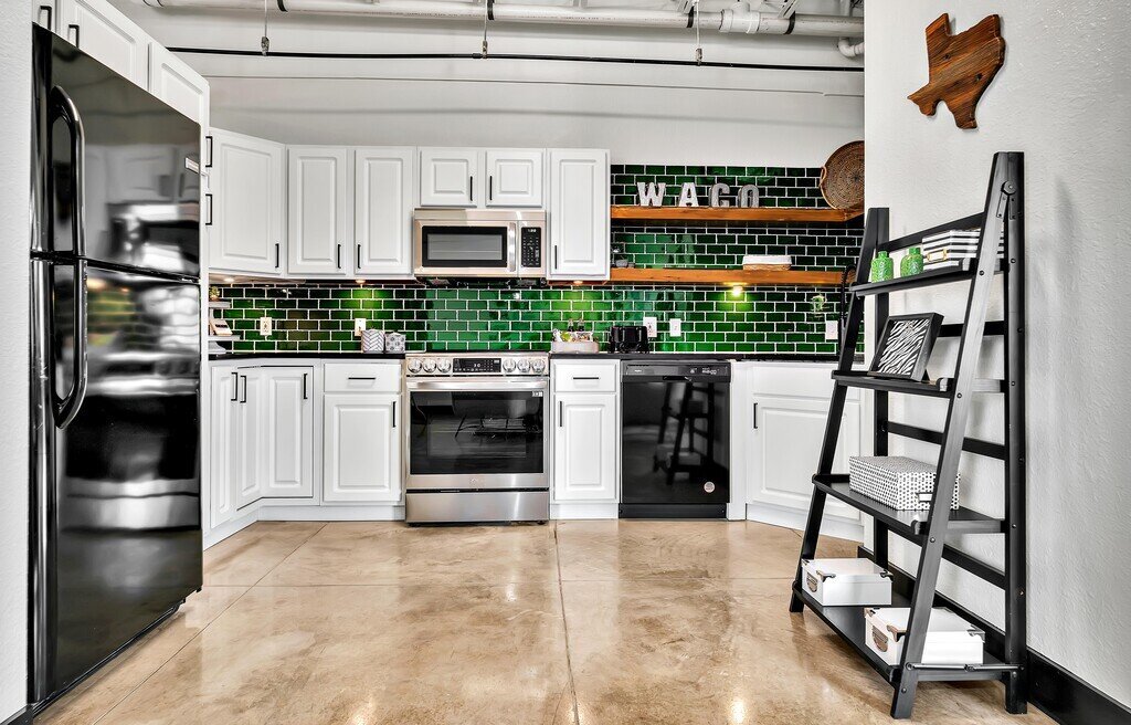 Fully stocked kitchen in this one-bedroom, one-bathroom vacation rental condo with sleeping space for four is walking distance from the Silos, McLane Stadium, and Baylor University in downtown Waco, TX