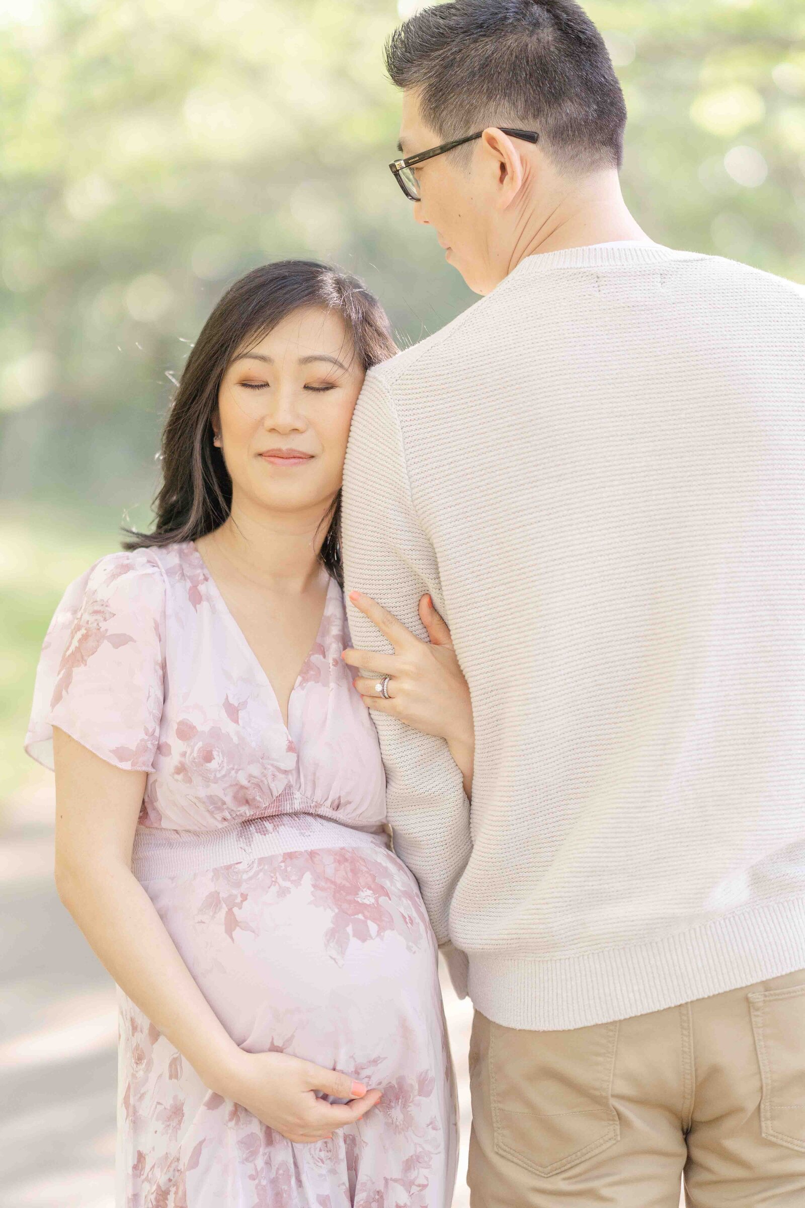 mom leaning on dad’s shoulder with eyes closed during Ashburn, VA maternity session