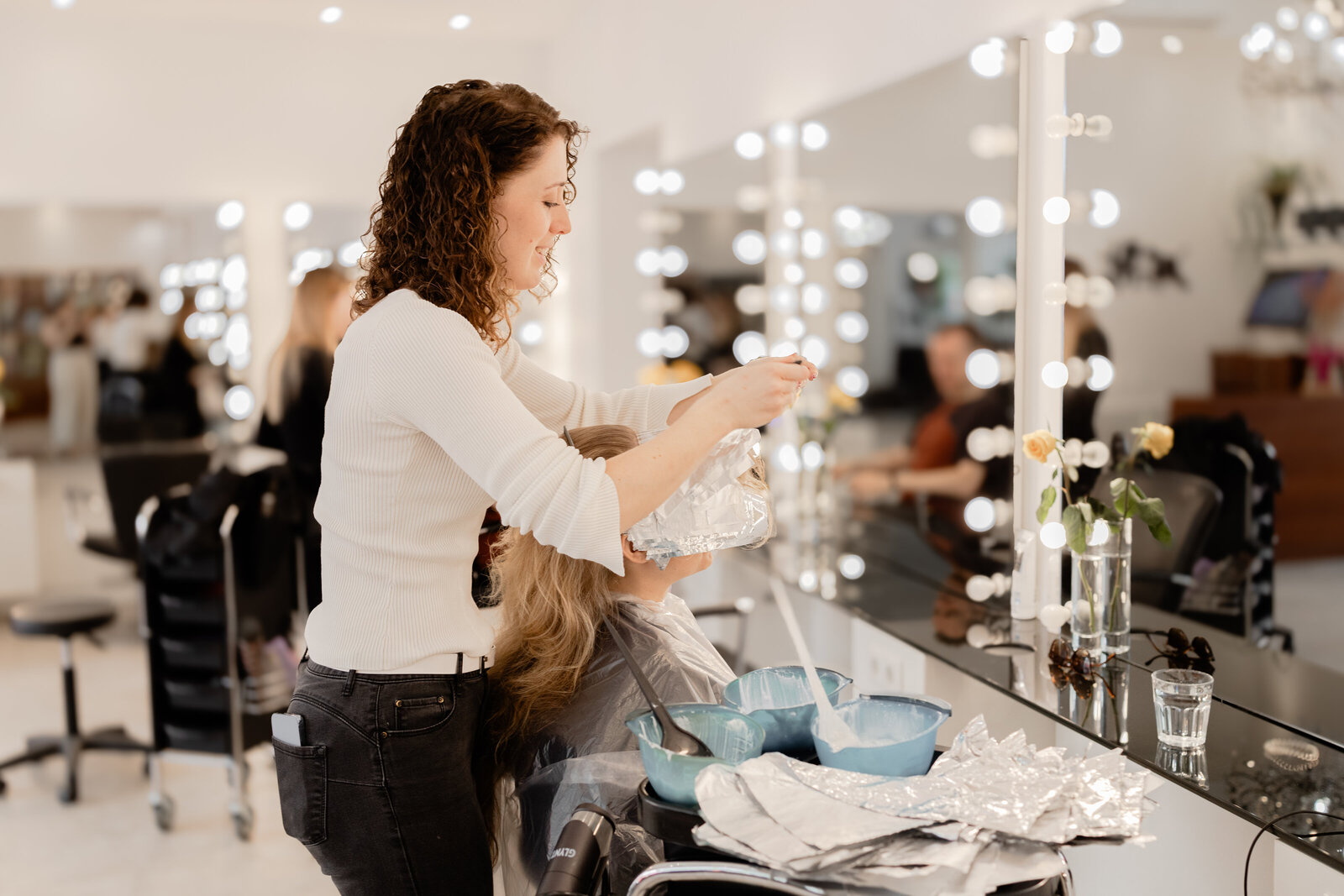 Friseur frisiert ein Mädchen