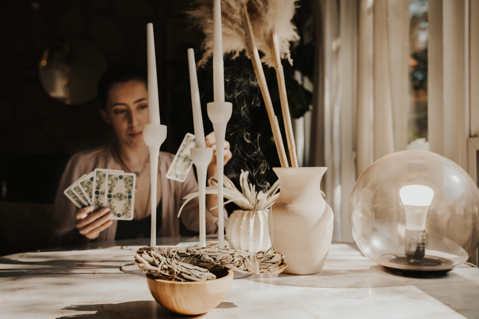 Branding Photographer,  a woman sits at a table examining tarot cards