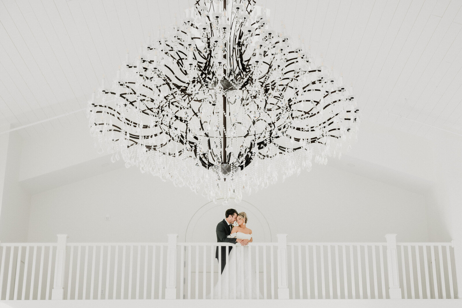 Bride and Groom embrace under a chandelier at the Westwind Hills wedding venue in Pacific, Missouri