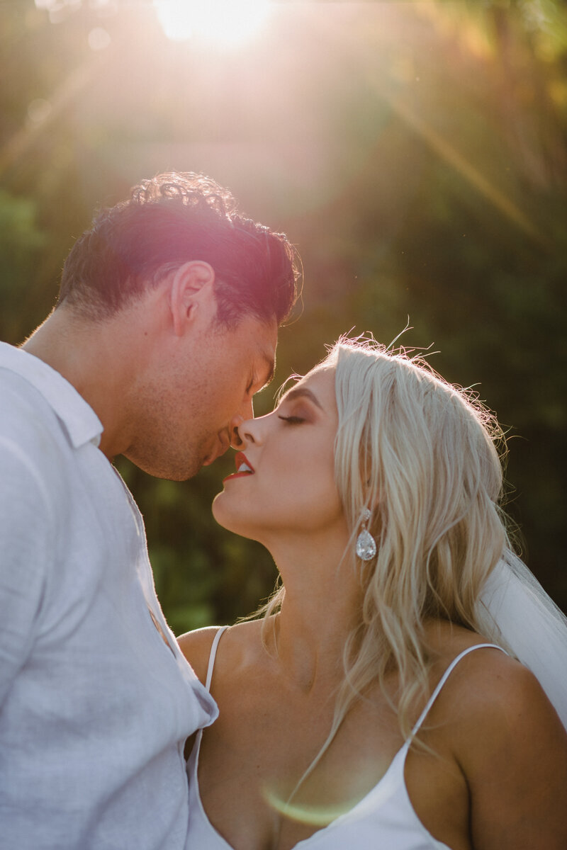 Bride and groom about to kiss with golden light