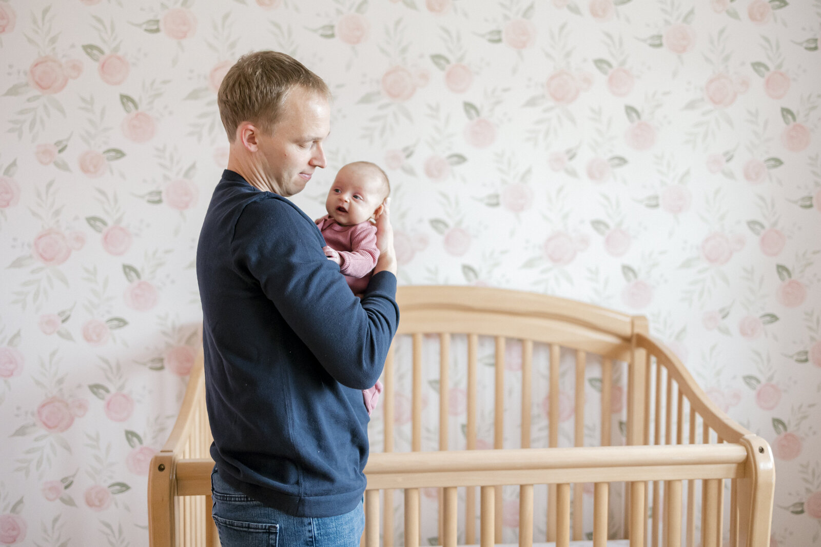 Father holding his newborn daughter in nursery