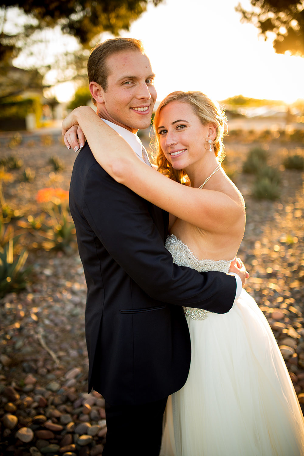 bride and groom smiling at sunset