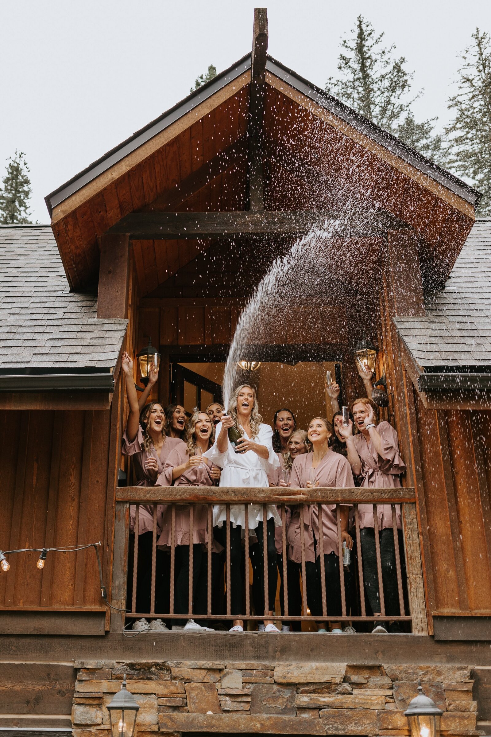 Bridal party pops champagne at their Stoneflower wedding venue.