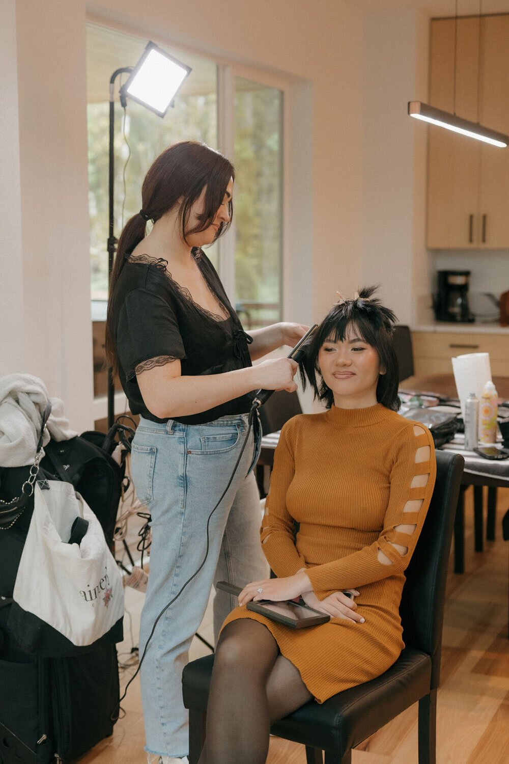 Bride getting her hair styled by a professional in a modern kitchen