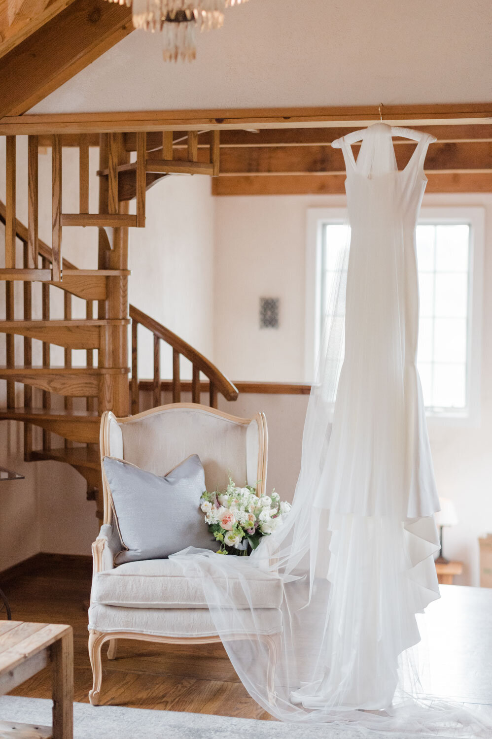 Wedding gown hanging near a spiral staircase