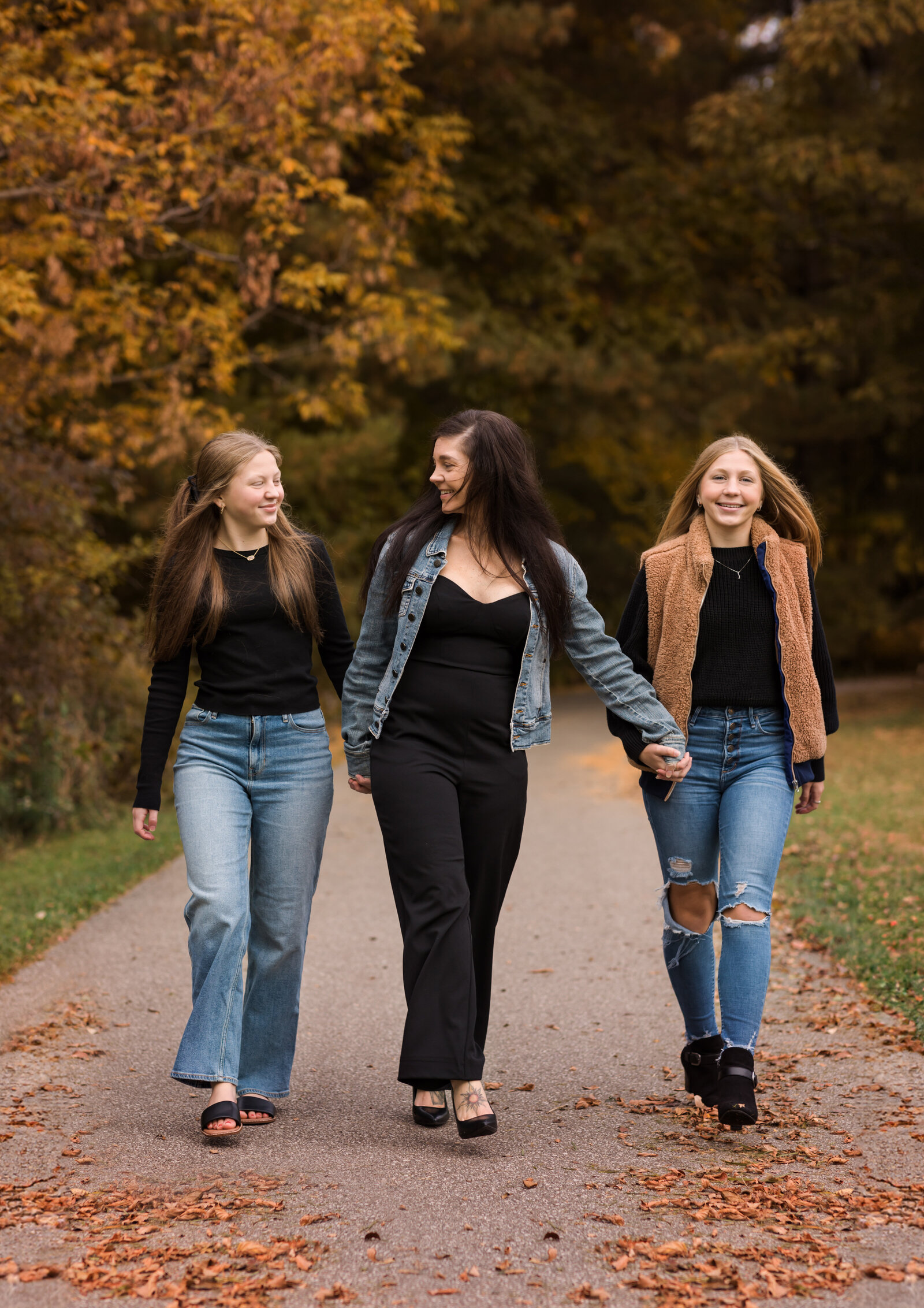 mom and two daughters posing for fall family portraits