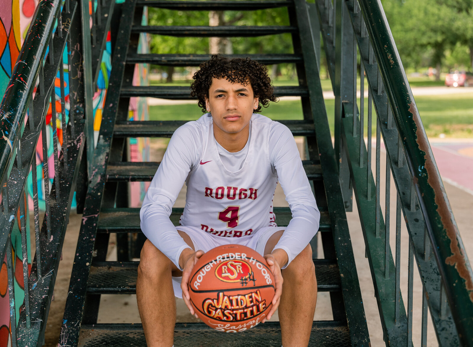senior boy seated with basketball