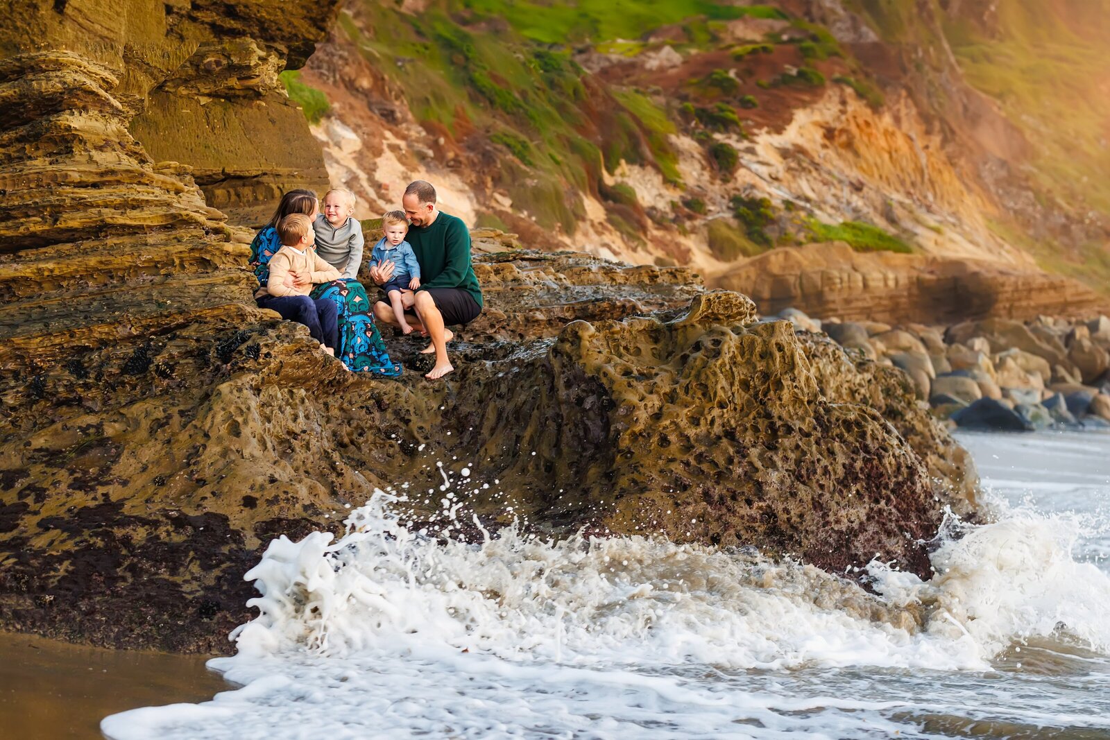 Family sitting on bluff at Santa Cruz Beach in Ocean Beach San Diego