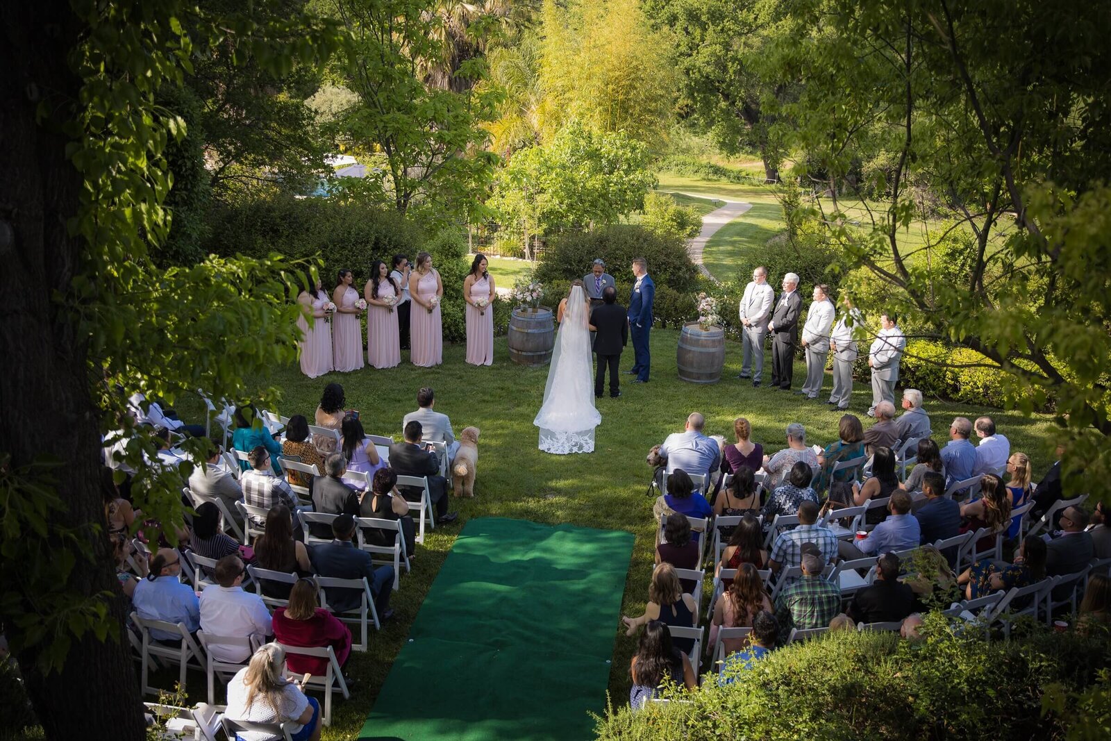 Sacramento wedding photography studio captures wedding ceremony from a top view with guests looking on as bride approaches groom at the alter.