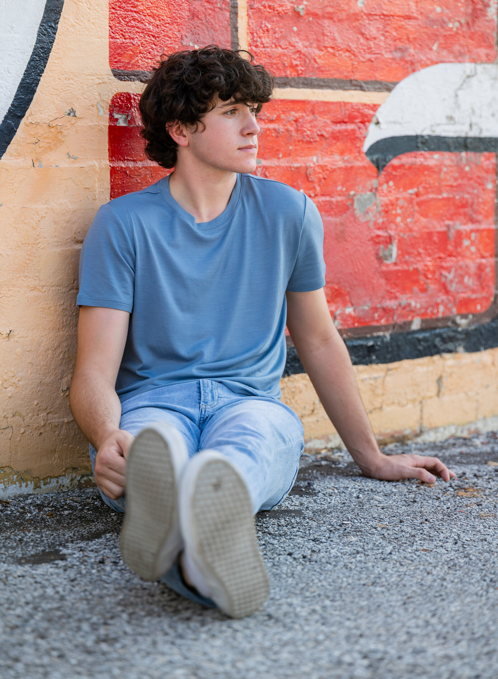 senior boy in front of mural