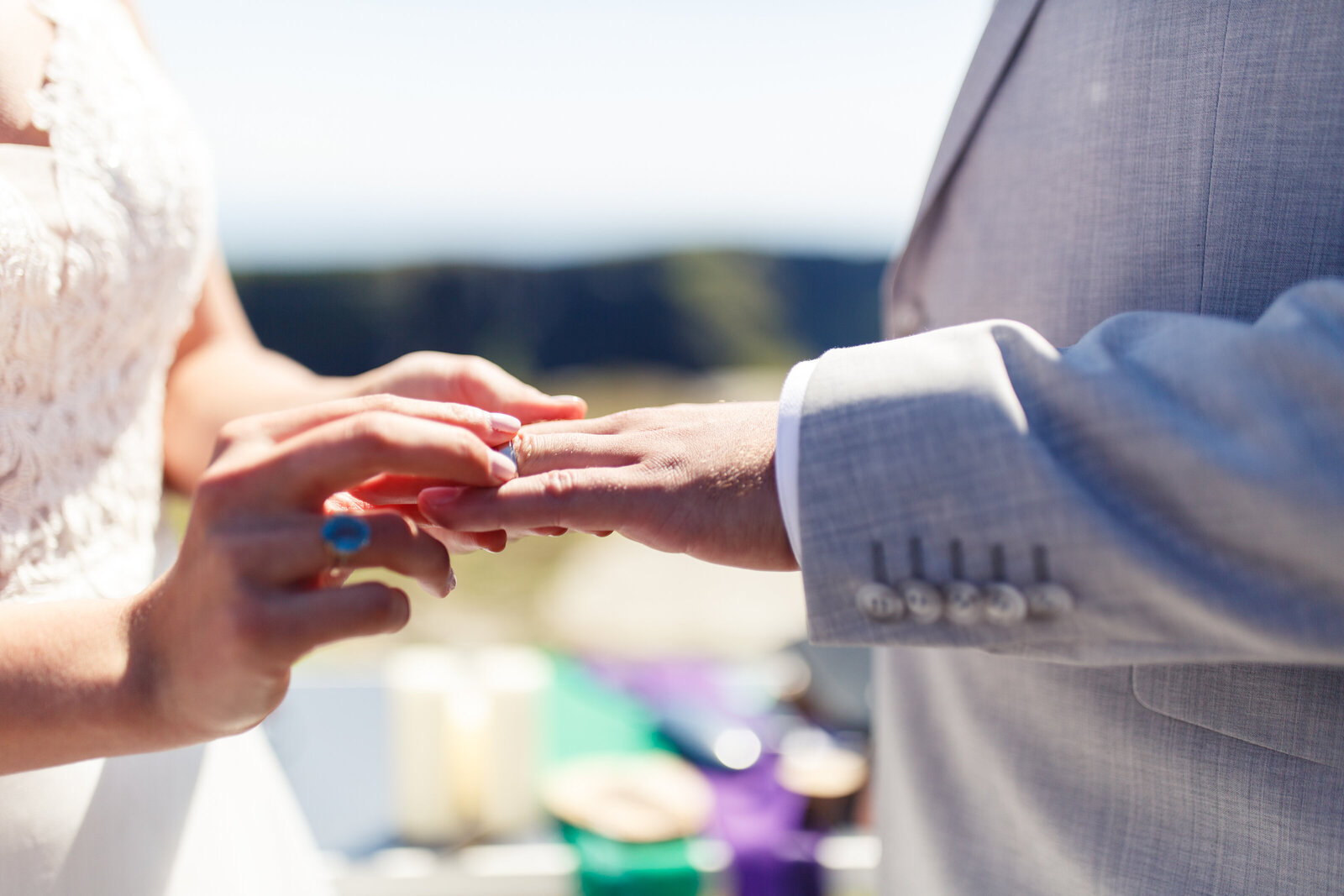bride putting ring on grooms finger