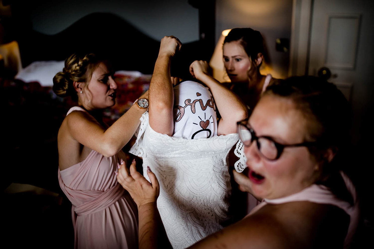 bridesmaids helping to dress the bride on her wedding day