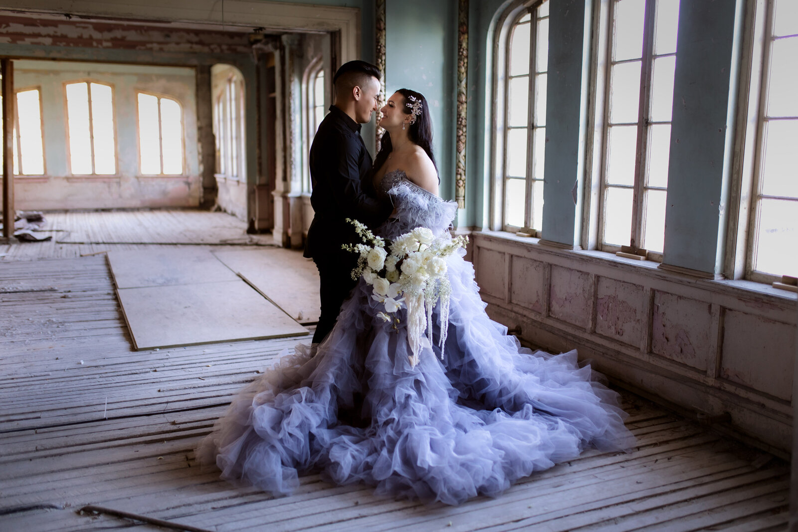 Bride in a dramatic tulle gown sitting elegantly in a rustic indoor setting, showcasing styled shoots for adventurous photographers in the Pacific Northwest.