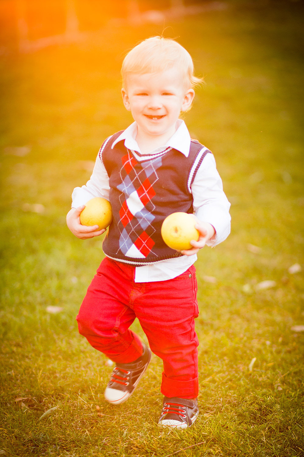 san diego family photographer | little boy walking and laughing carring lemons