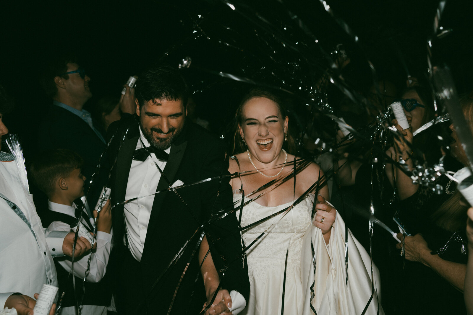 A married couple exiting their Tennessee wedding with silver streamer poppers captured in a documentary way. 