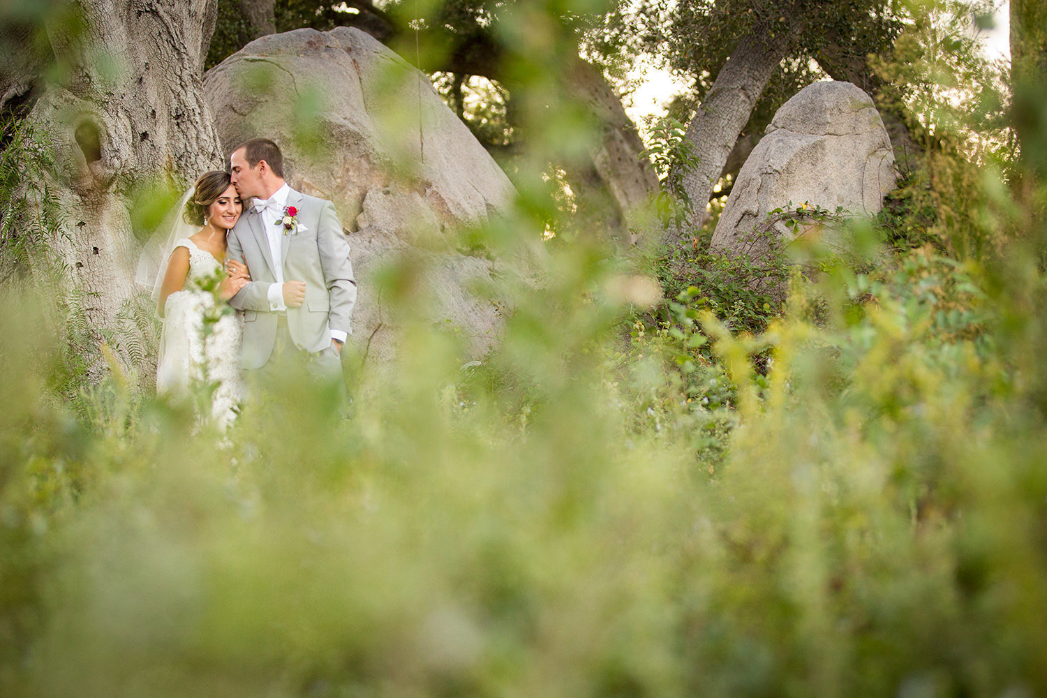 bride and groom kissing in a open field