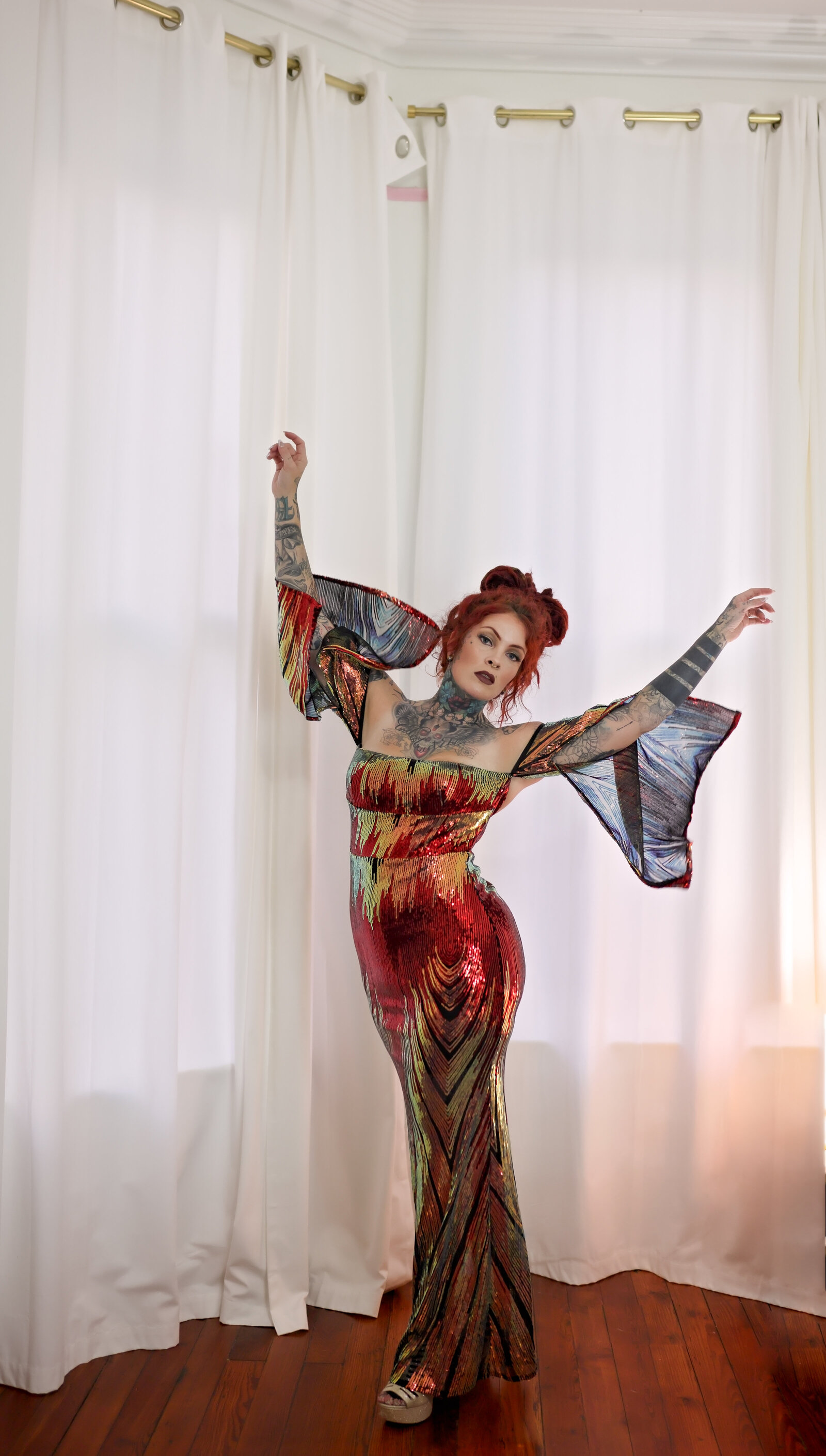 Savannah Boudoir Photography and Glamour showcases gorgeous red headed woman with dreads in colorful and sparkly designer glamour gown movement of arms
