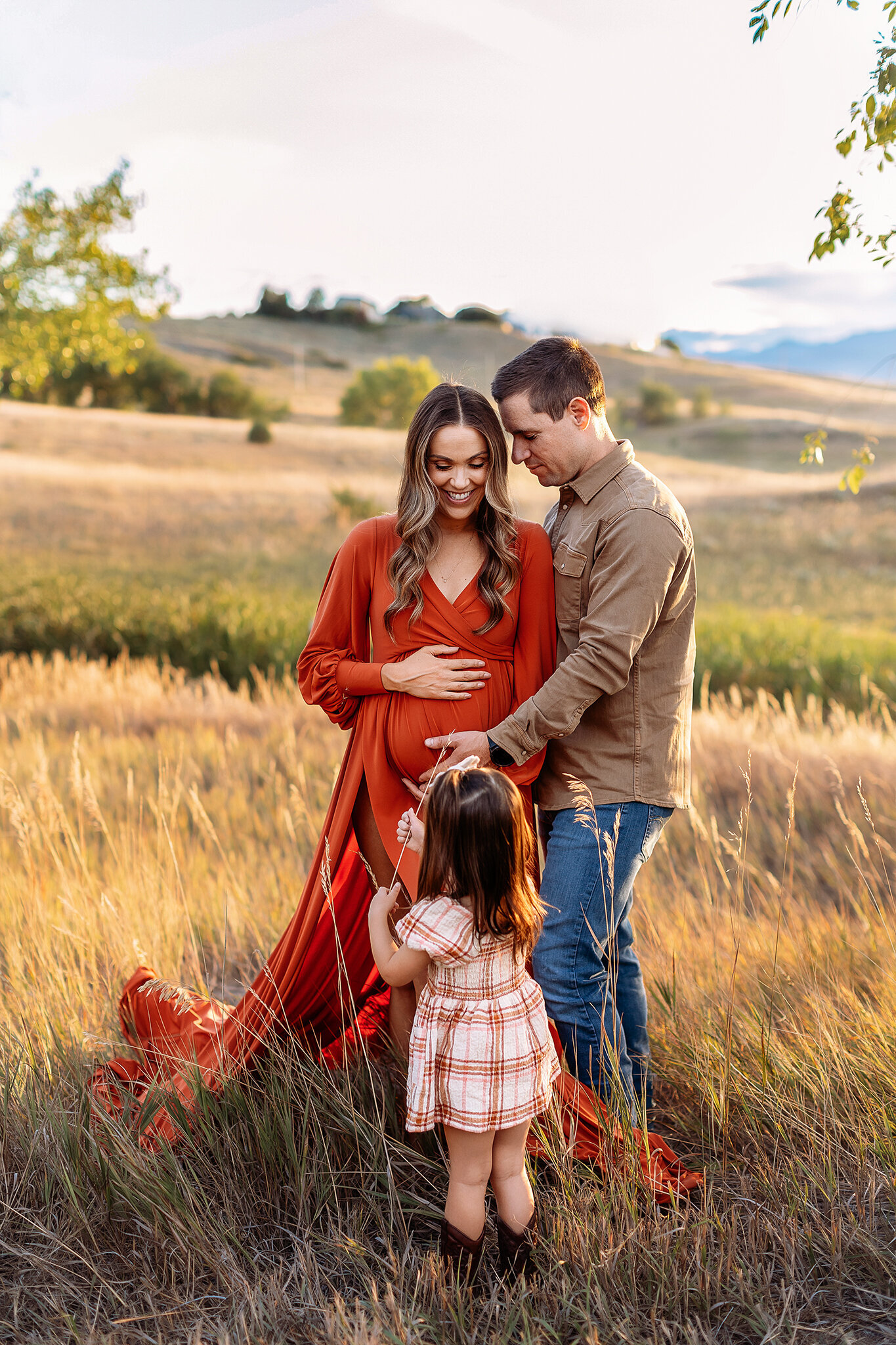 toddler girl kissing moms baby bump during their broomfield family maternity photos