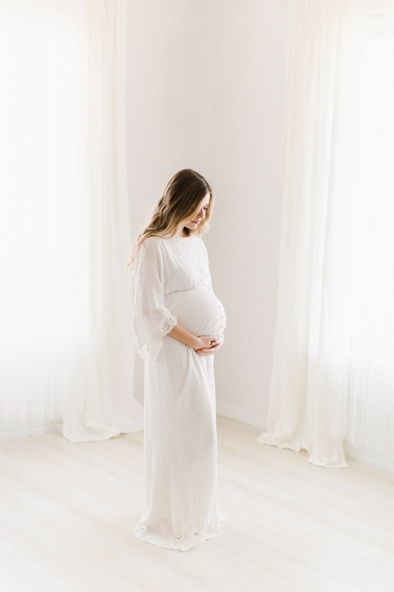 Bright and airy maternity photo shoot in luxury studio.