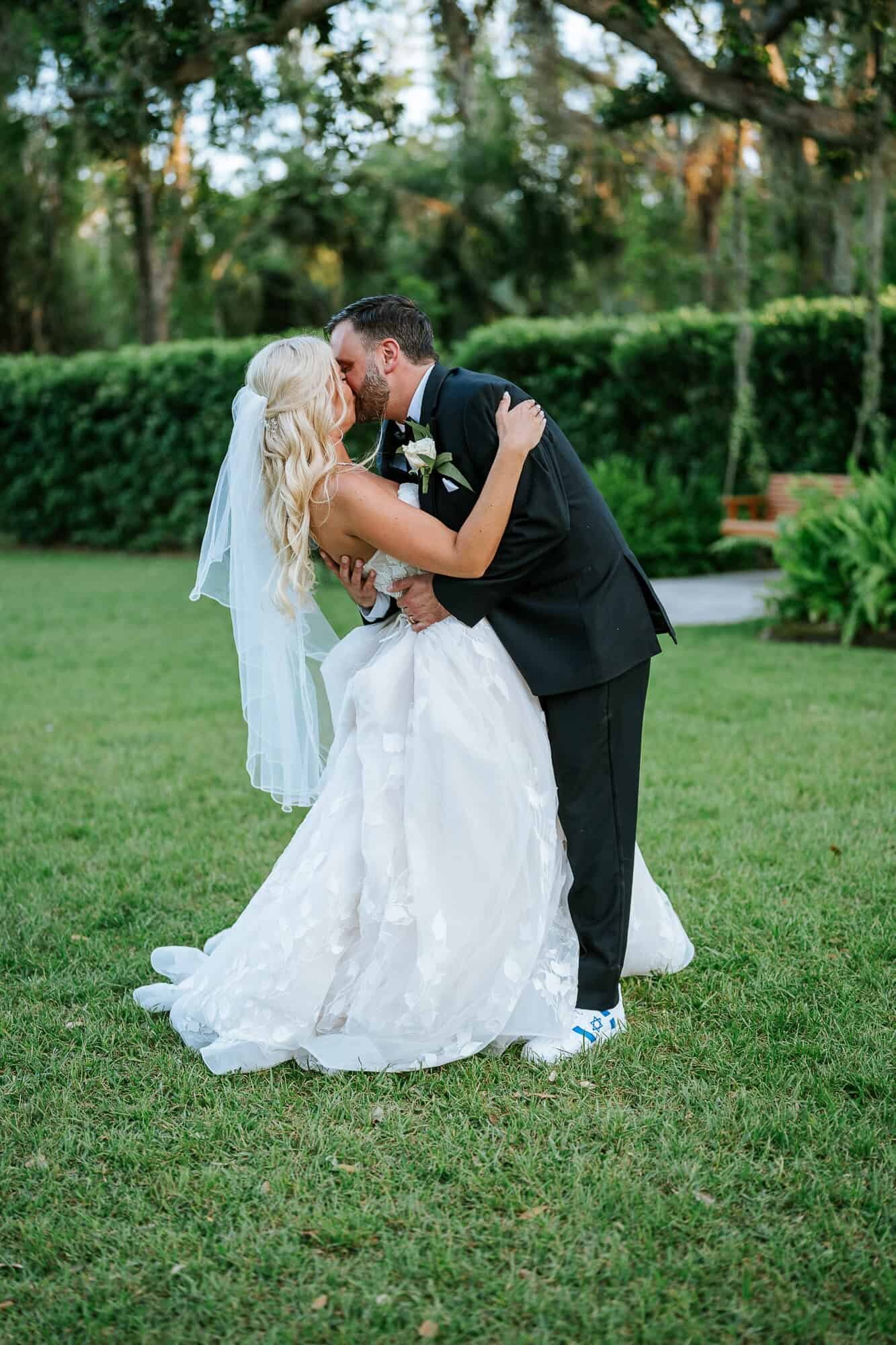 Bride and groom kissing under the oak canopy at Baker’s Ranch in Parrish, FL.