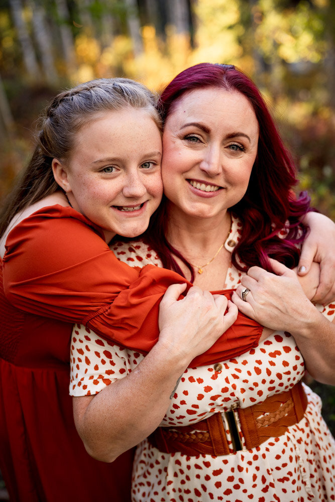 a daughter in a red dress gives her mom the biggest hug ever