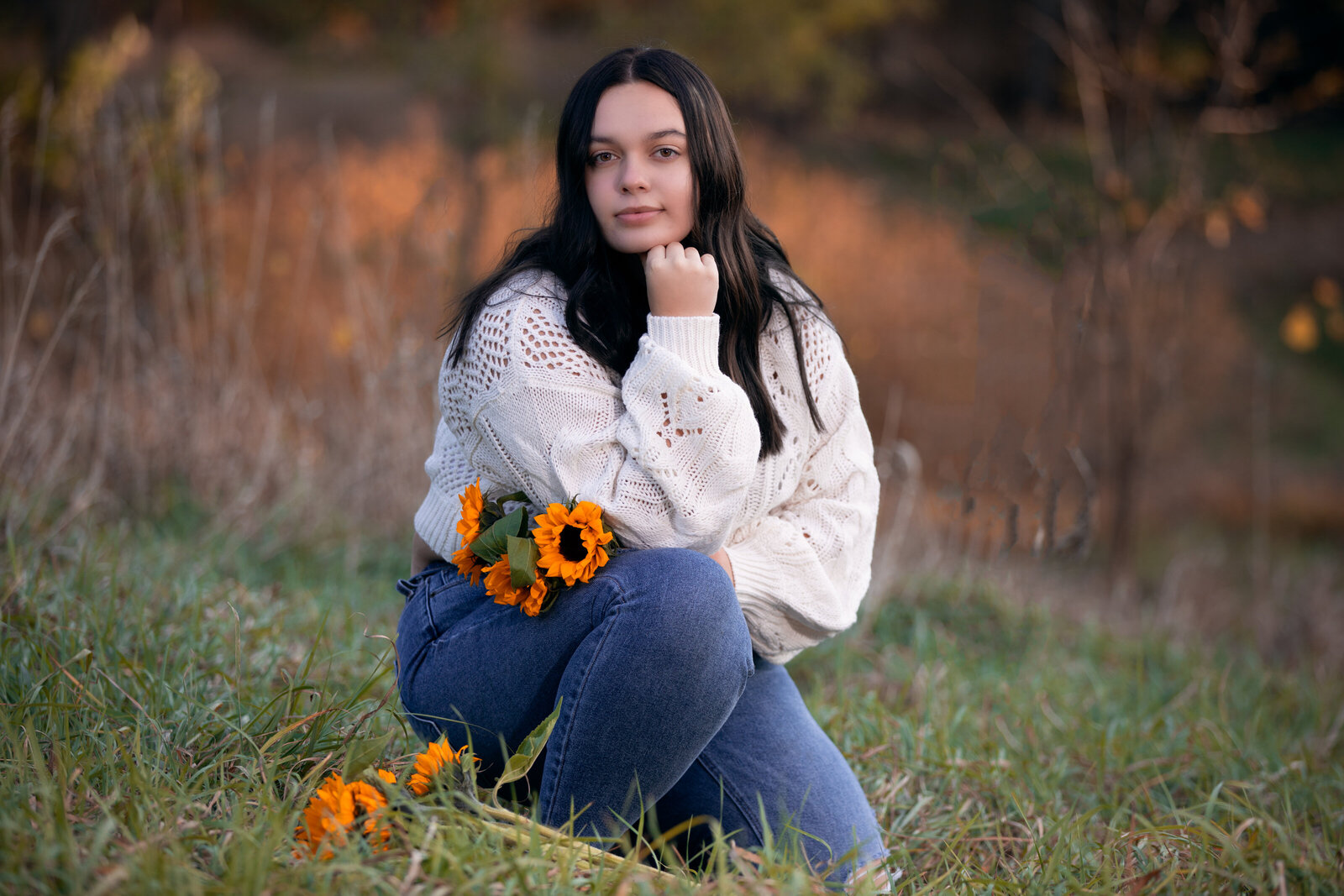 Senior holds sunflowers during her senior photo shoot