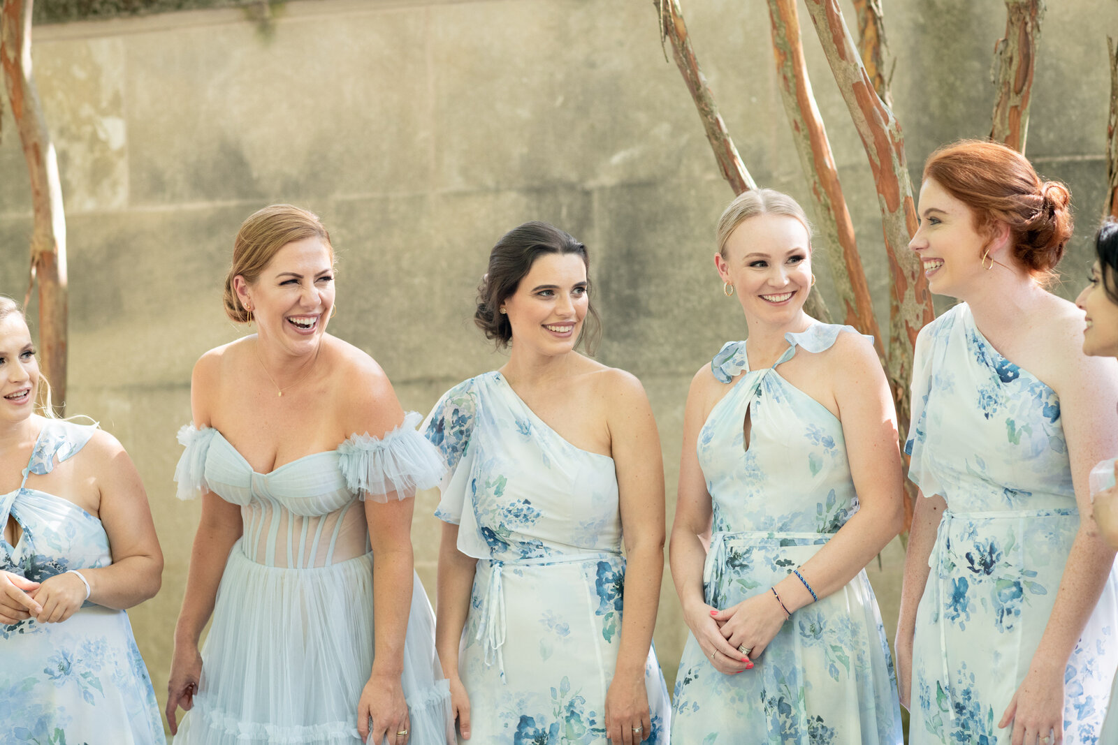 Bridesmaids smile to one another.