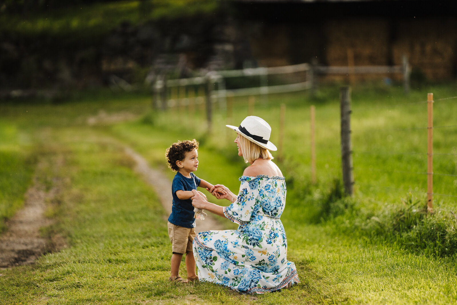 mom kneels on farm with toddler boy