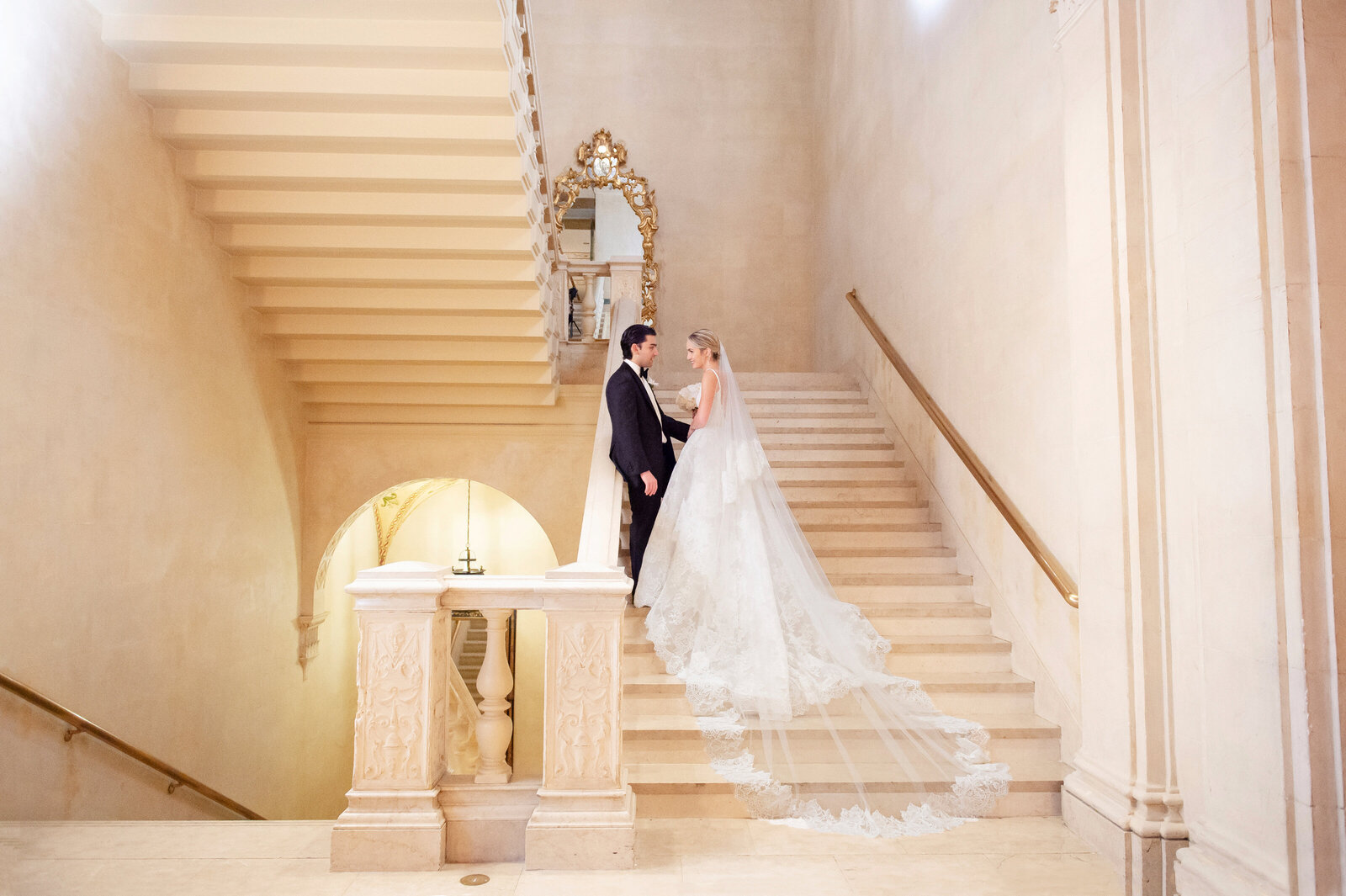 Bride and groom standing on marble staircase