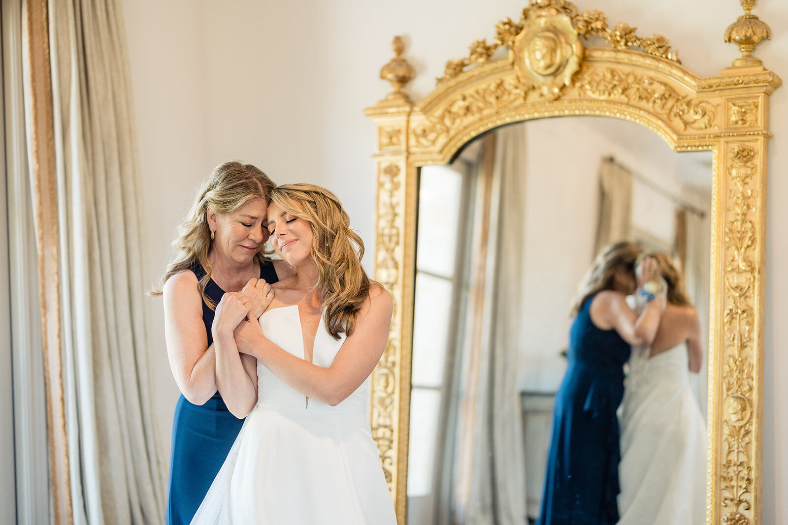 A bride and her mother embrace in the bridal suite at a Vista Valley Country Club Wedding