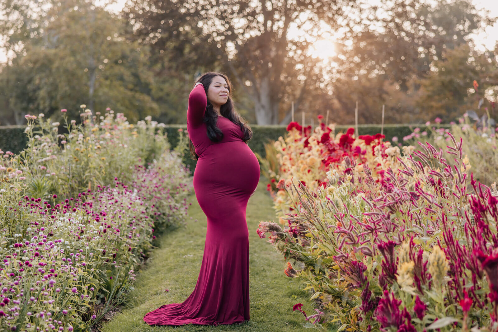 Pregnant woman in empowering pose in flower garden