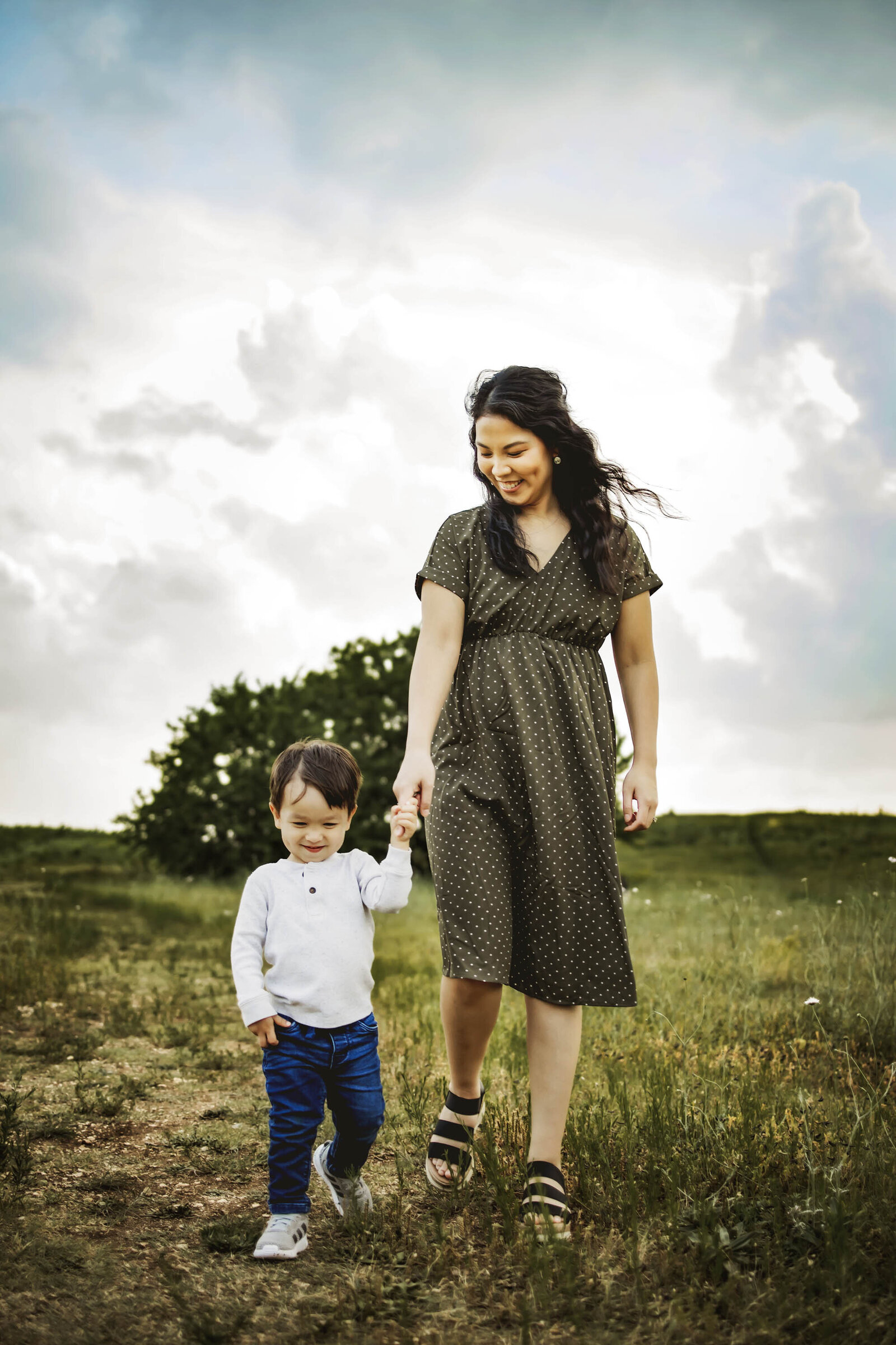 mom and son walking in a field in Plano texas