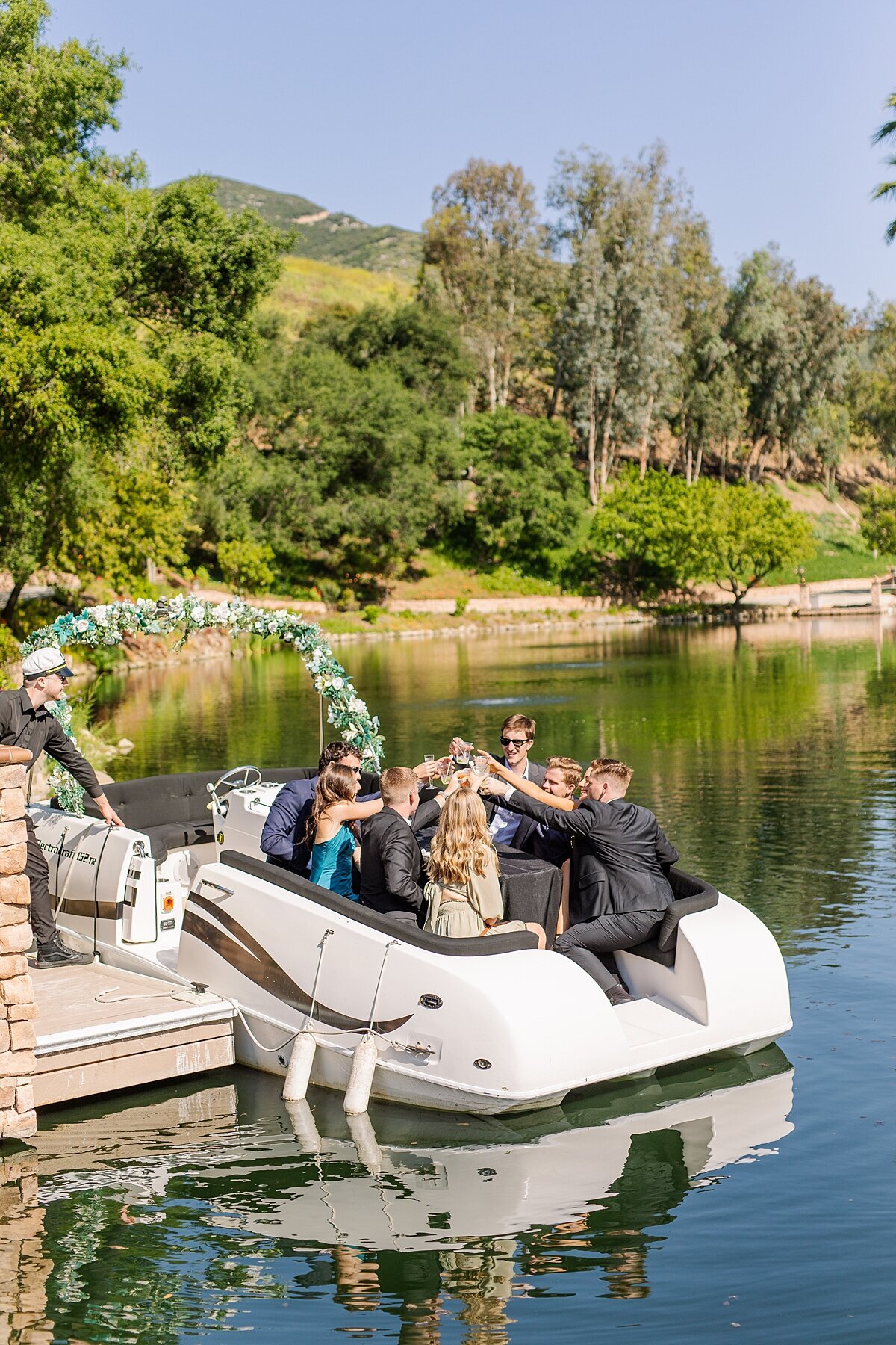 Wedding guests sharing champagne toast on a boat at Los Willows wedding venue in San Diego.