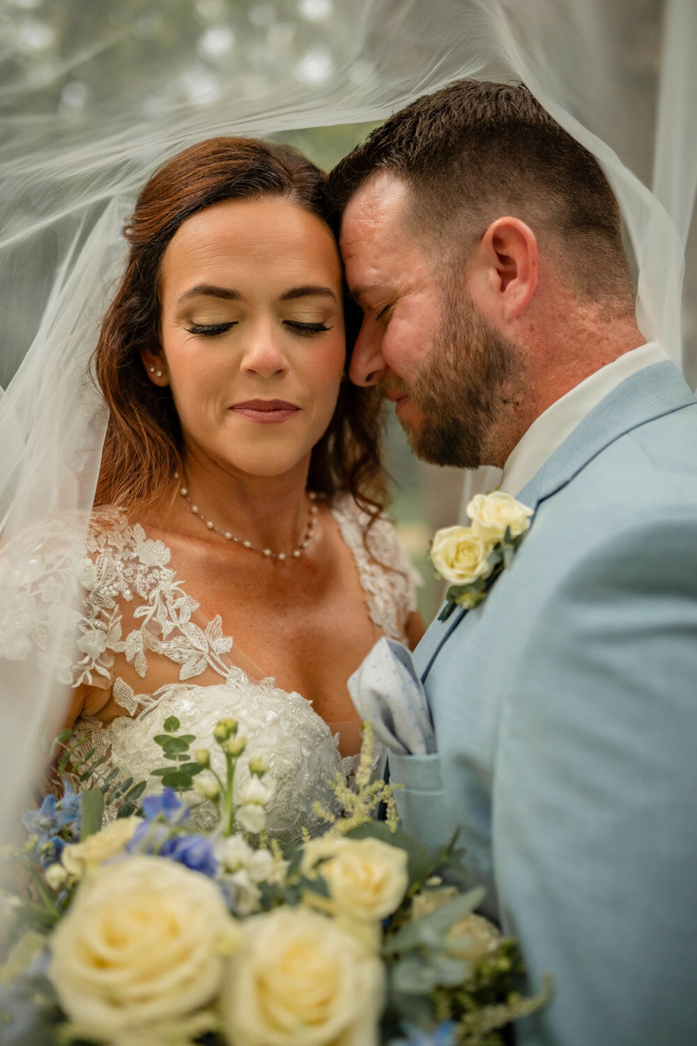 Photo of bride and groom closing their eyes
