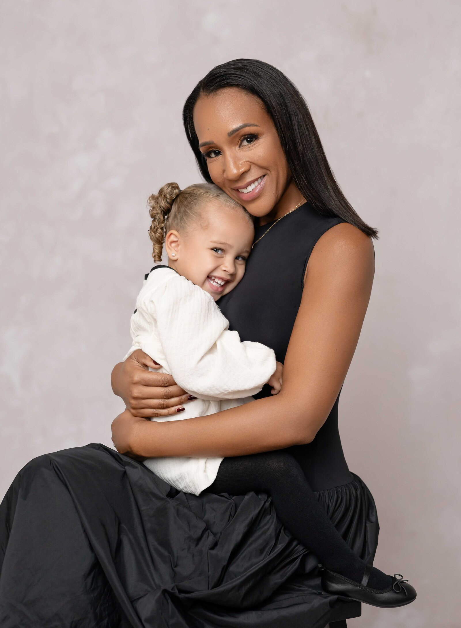 Mom snuggling baby girl on lap. Family photo taken by Jenni Nikki Photography at Atlanta photography studio.