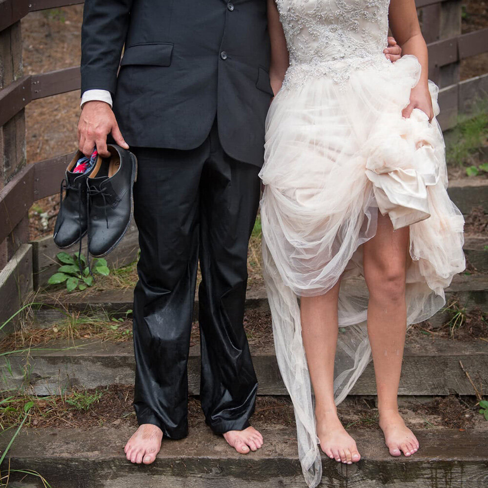 bride and groom in wet clothes on steps showing only their legs