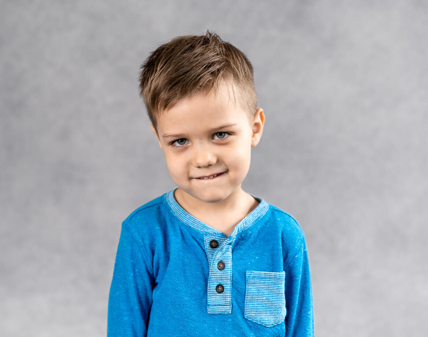 A young boy smirks.