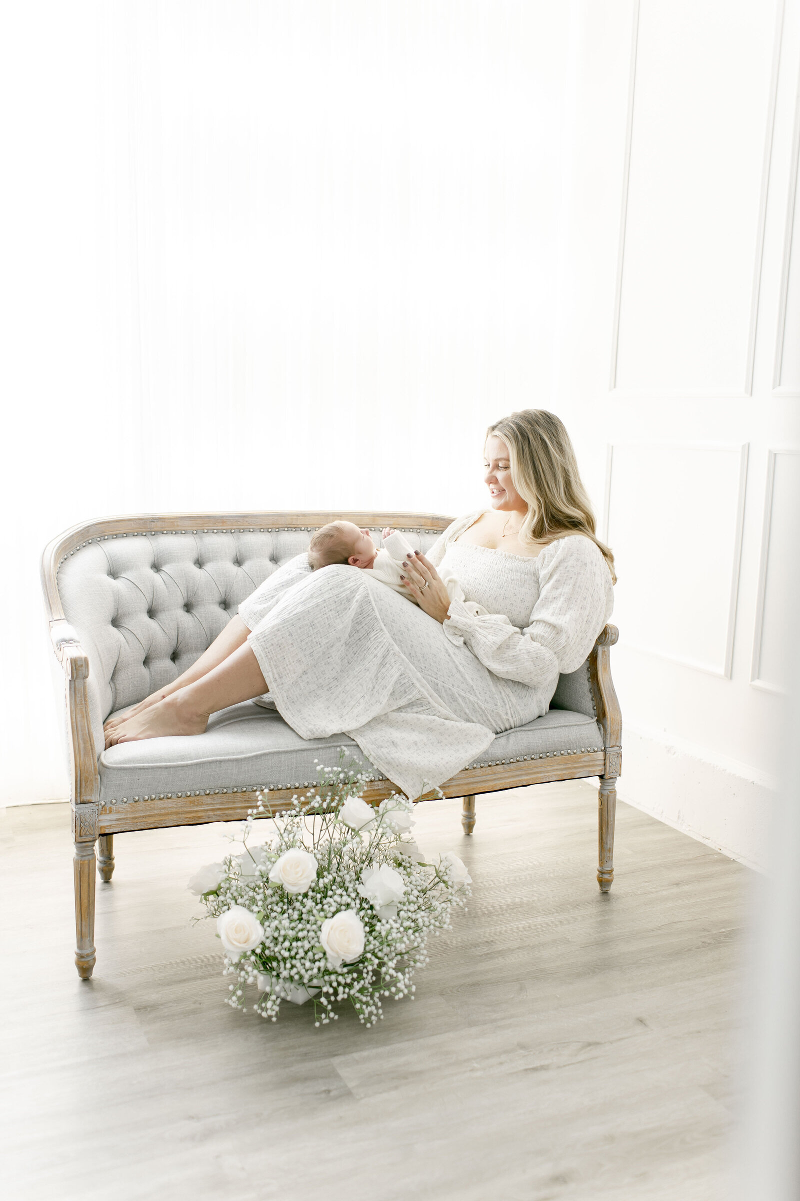 mom lying on sofa snuggling newborn baby taken by nj newborn photographer ally kimpton