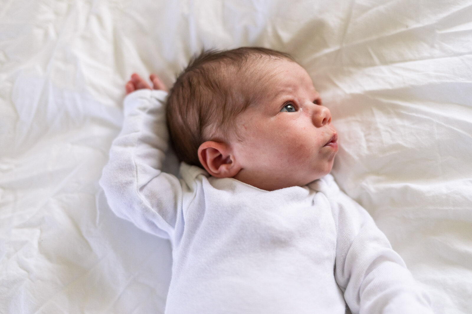 Kansas_City_Newborn_Photography_baby_stretching_on_white_blanket-15
