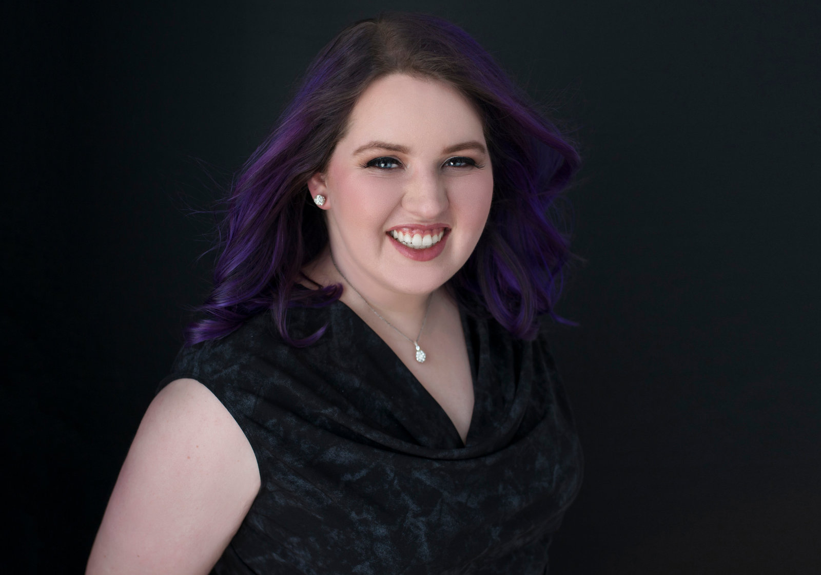 Personal branding Photo studio  of a woman smiling wearing black dress and  necklace and  purple color hair